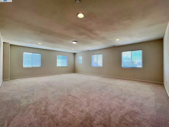 an empty room with a projector and windows