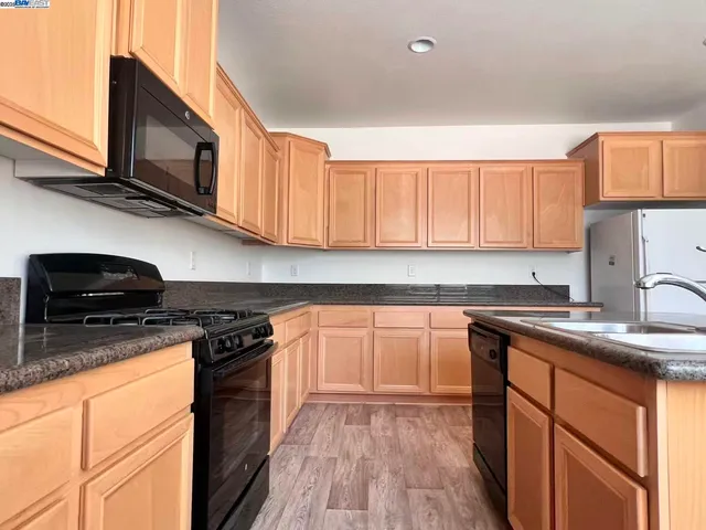 a kitchen with stainless steel appliances granite countertop a sink stove and microwave