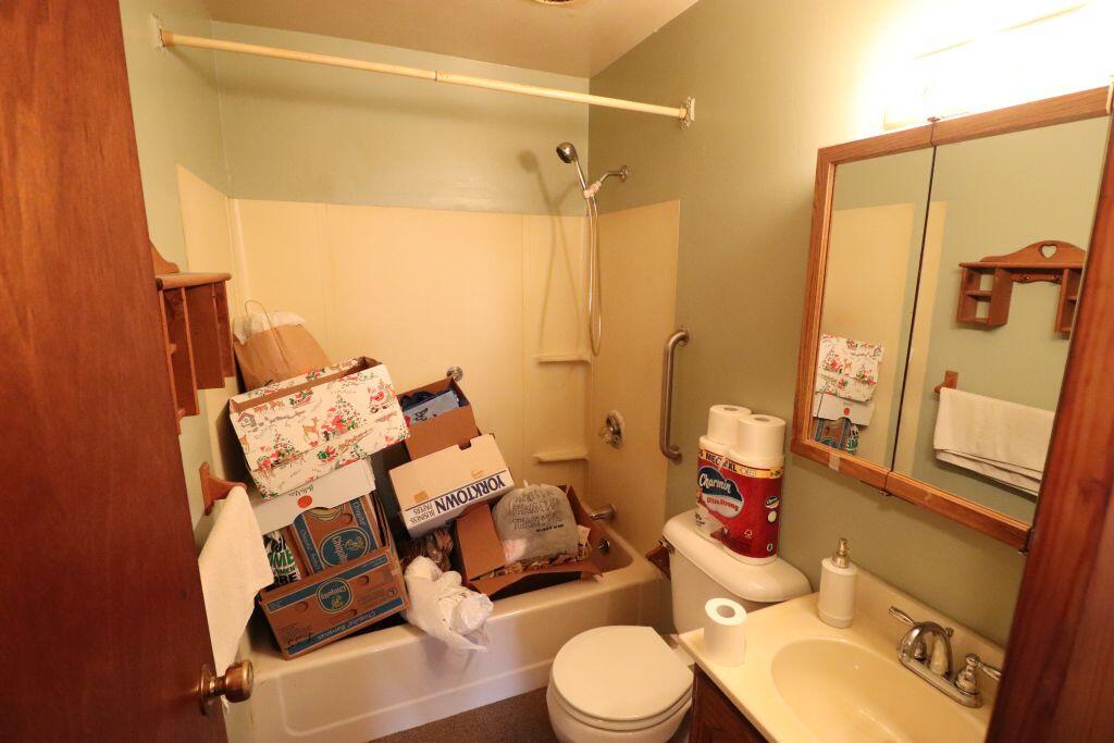 629 Superior Street Michigan City, IN 46360 - Photo 17 of 35 a white toilet sitting next to a bathroom sink and a mirror