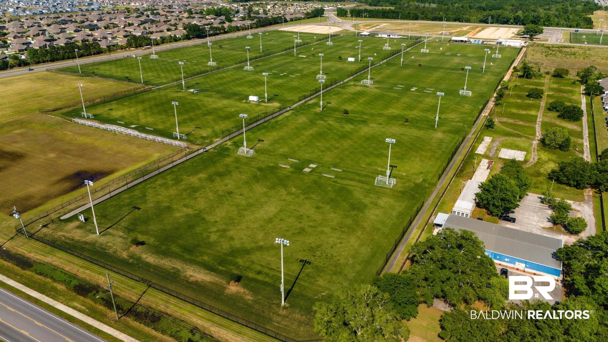 2651 South Juniper Street, Unit 705 Foley, AL 36535 - Photo 29 of 37 Expansive grounds featuring multiple green fields, perimeter fencing, and numerous tall light poles