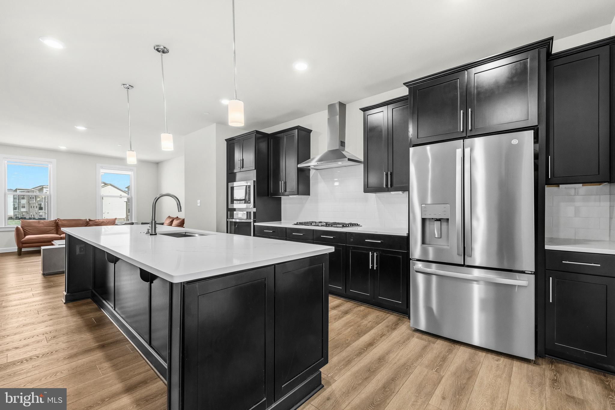 103 Brown Branch Road Laurel, MD 20708 - Photo 2 of 35 a kitchen with kitchen island a sink appliances and cabinets