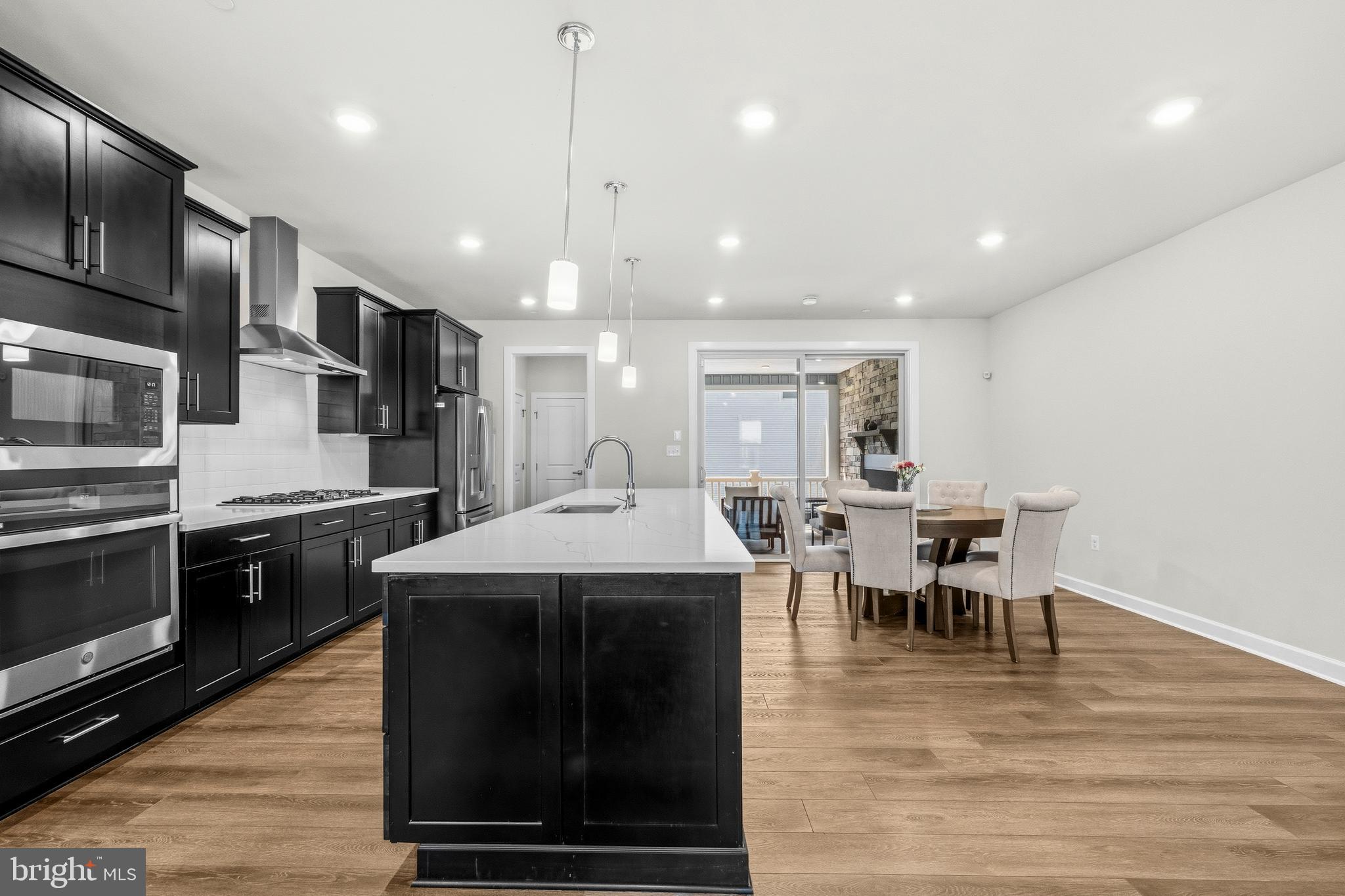 103 Brown Branch Road Laurel, MD 20708 - Photo 9 of 35 a kitchen with stainless steel appliances kitchen island granite countertop a stove a sink and a microwave
