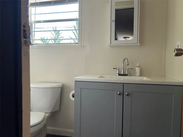 a bathroom with a toilet sink and mirror