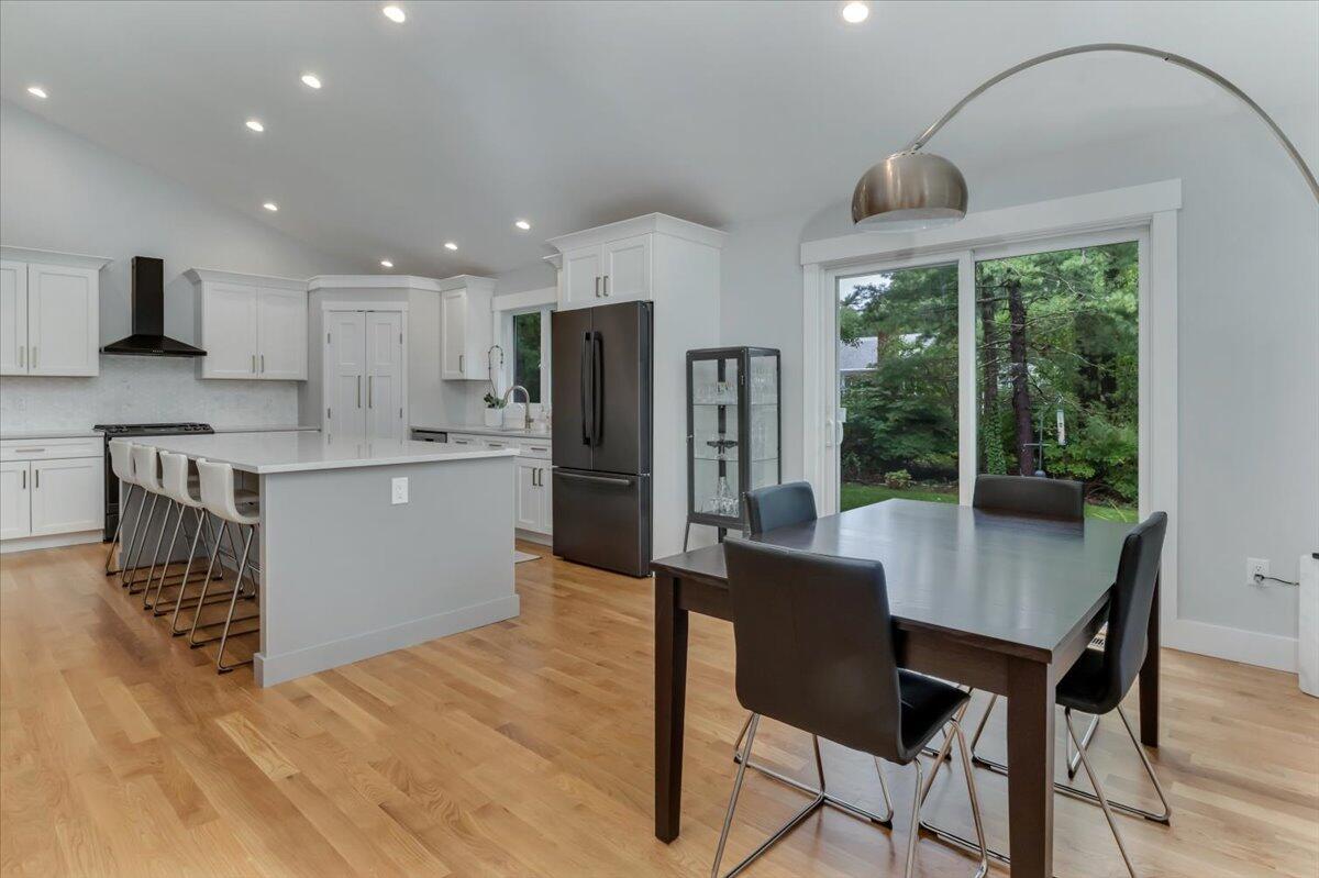 14 Valley Brook Road Centerville, MA 02632 - Photo 16 of 47 a kitchen with stainless steel appliances granite countertop a stove top oven a sink dishwasher a dining table and chairs with wooden floor