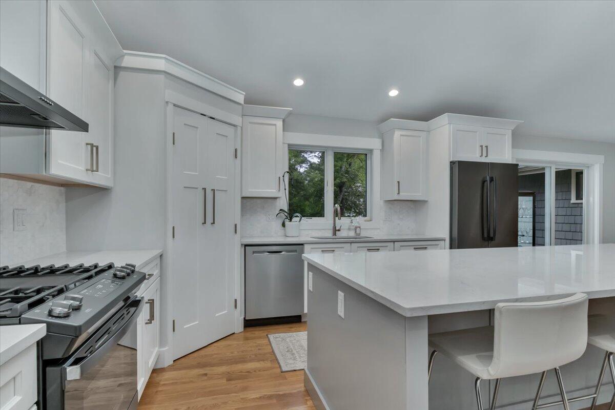 14 Valley Brook Road Centerville, MA 02632 - Photo 9 of 47 a kitchen with stainless steel appliances granite countertop a stove top oven a sink dishwasher and a refrigerator with wooden floor