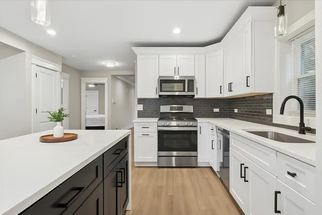 a kitchen with sink a microwave and cabinets