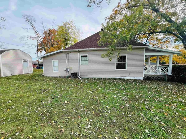 a view of a house with a small yard and a large tree