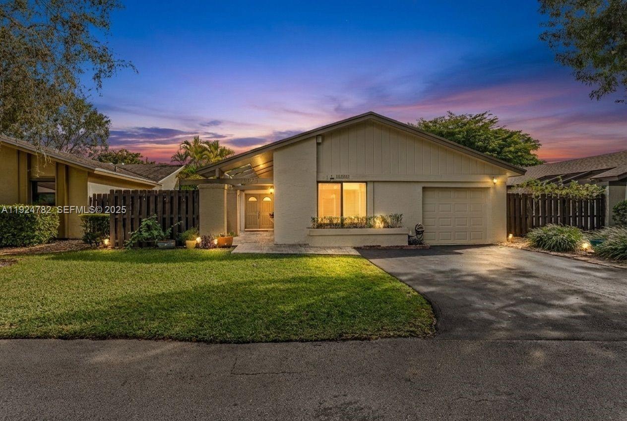 a front view of a house with a garden and yard