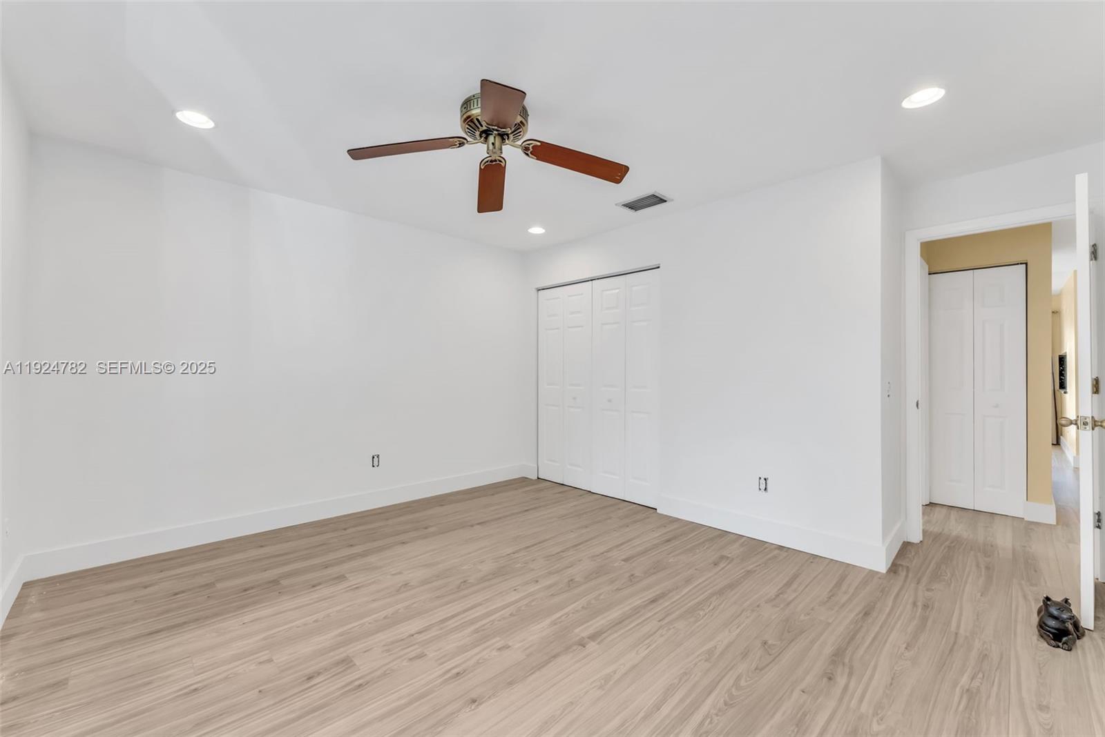 11525 Southwest 135th Court Miami, FL 33186 - Photo 19 of 42 an empty room with wooden floor ceiling fan and window