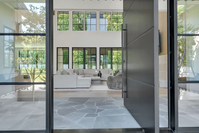 a living room with furniture large window and flat screen tv