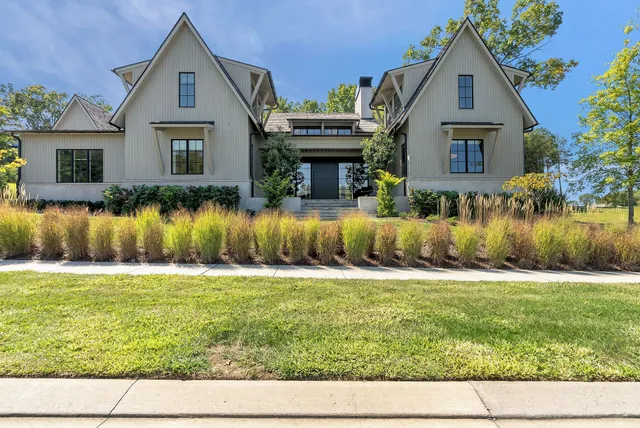 a front view of a house with a garden and plants