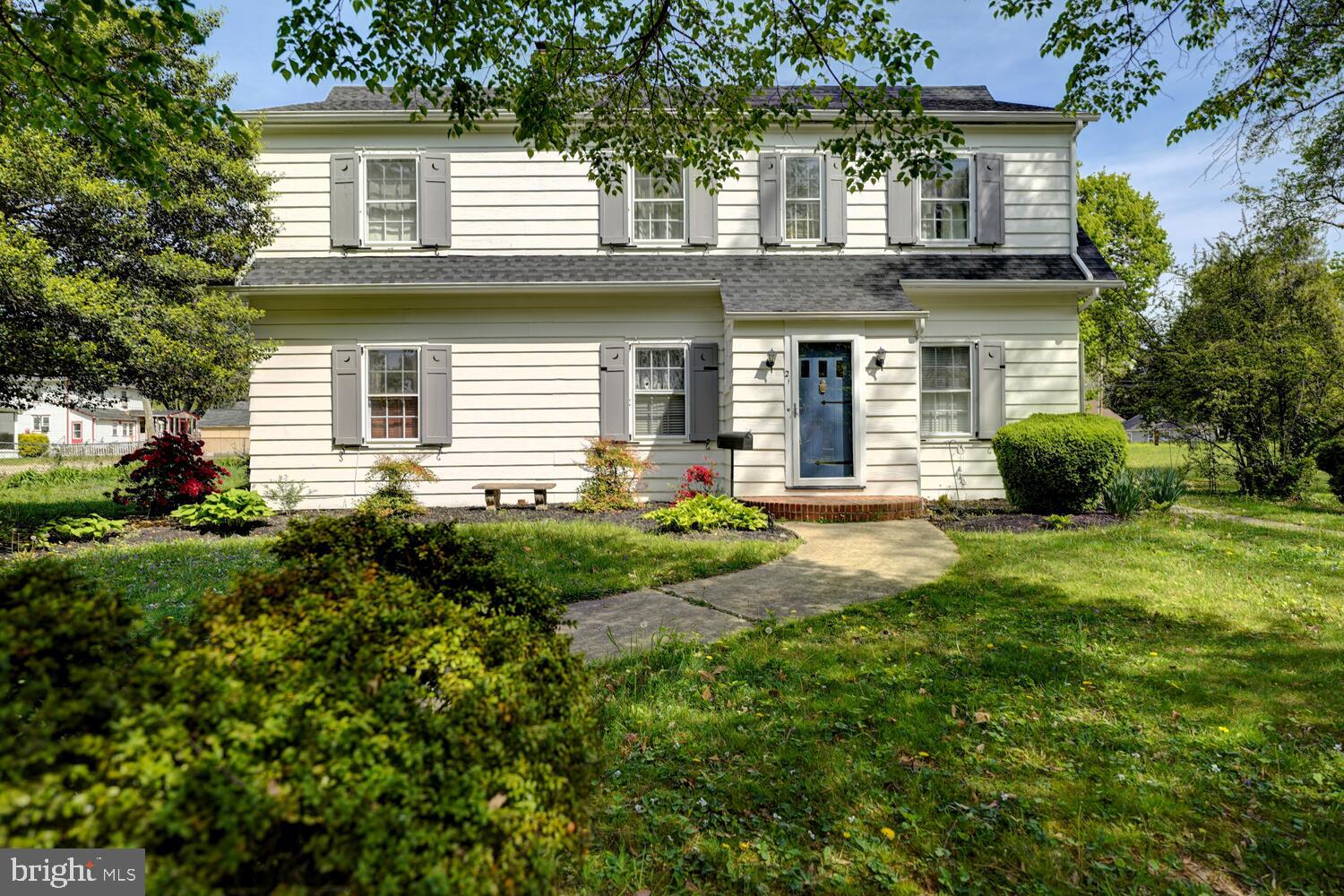 a front view of a house with a yard and potted plants