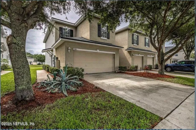 a front view of a house with a garden and trees