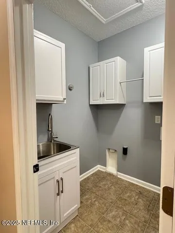 a kitchen with white cabinets and a sink