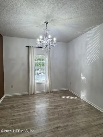 a view of a big room with wooden floor and chandelier
