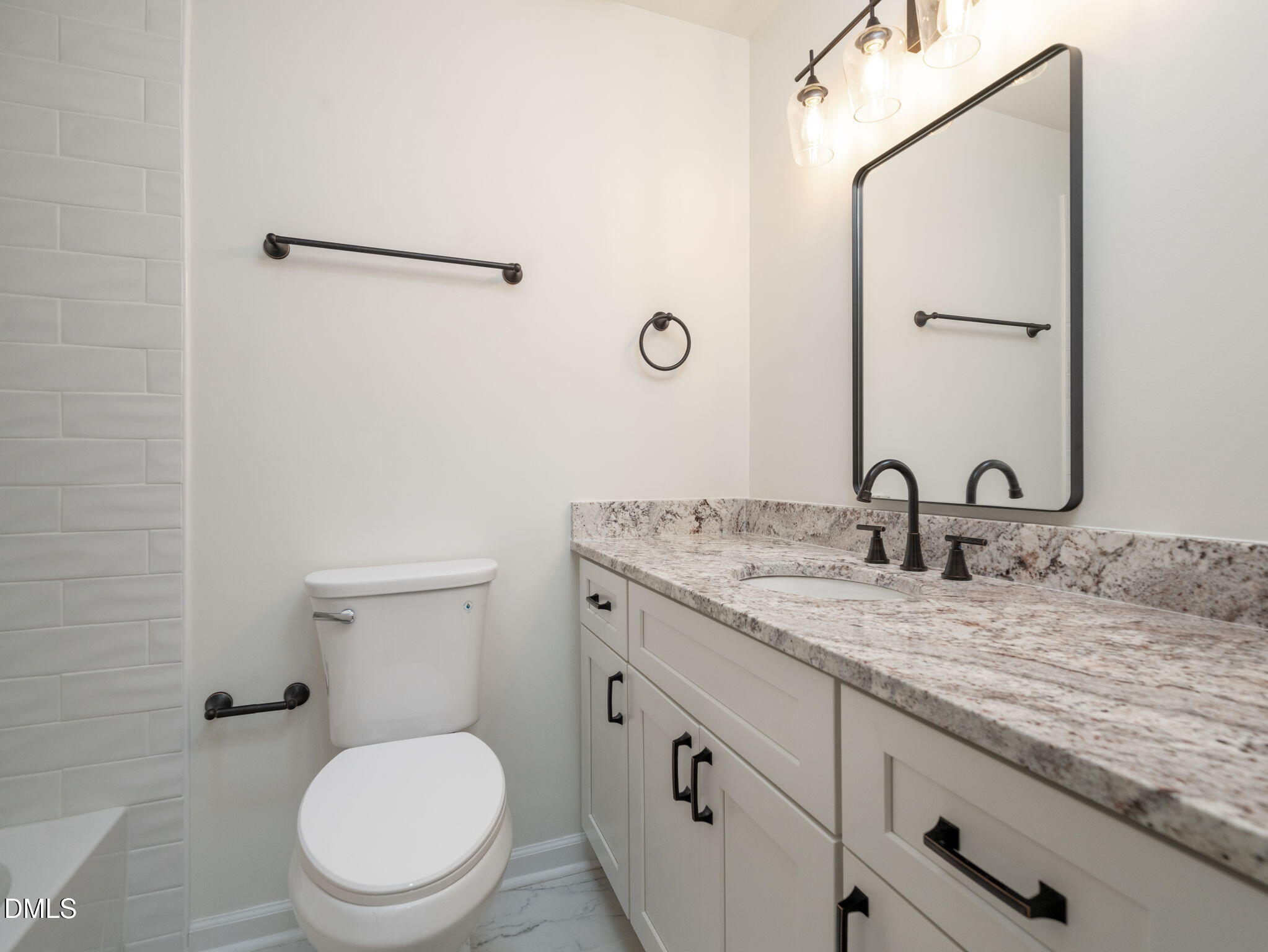 705 Villawood Court Raleigh, NC 27615 - Photo 26 of 31 The hall bath features lovely white cabinetry with updated hardware, new mirror and lighting and LVT flooring.