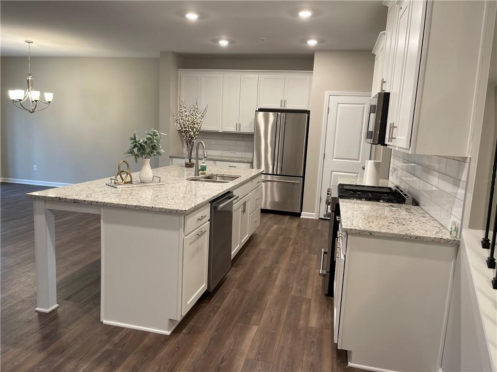 500 Duval Drive Alpharetta, GA 30009 - Photo 3 of 21 a kitchen with a sink a refrigerator and a stove top oven