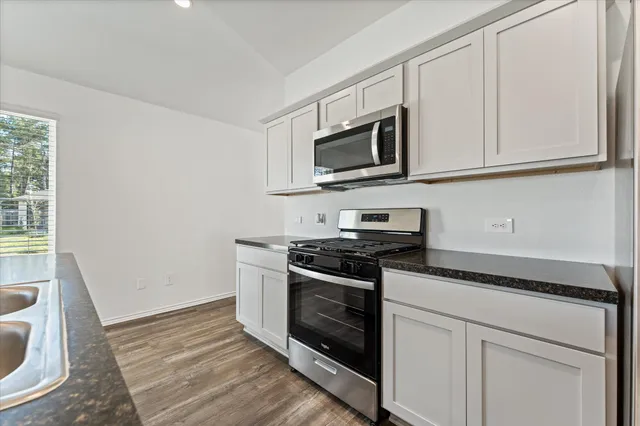a kitchen with white cabinets stainless steel appliances and a sink