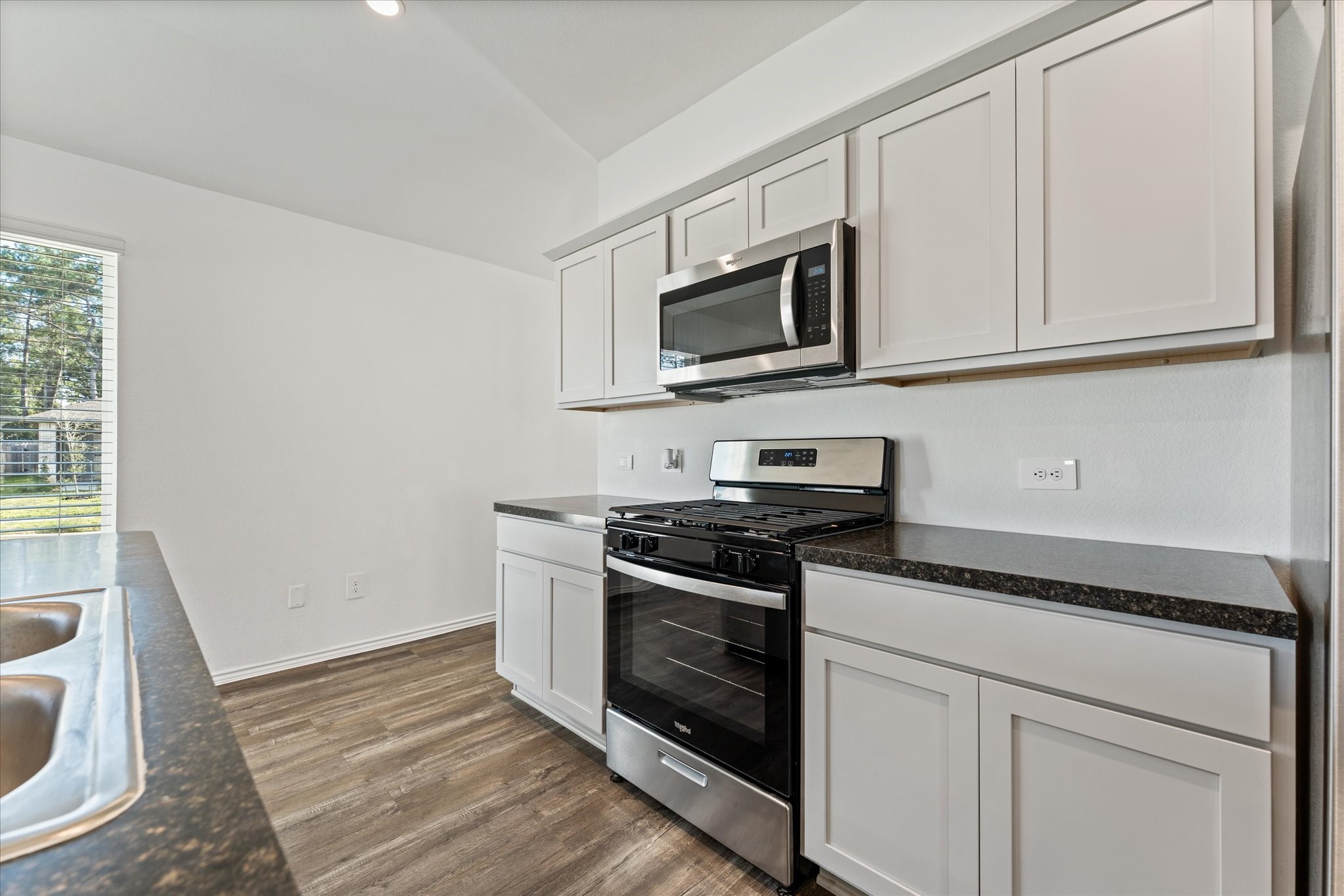 24210 Sandstone Valley Lane Spring, TX 77373 - Photo 13 of 33 a kitchen with white cabinets stainless steel appliances and a sink