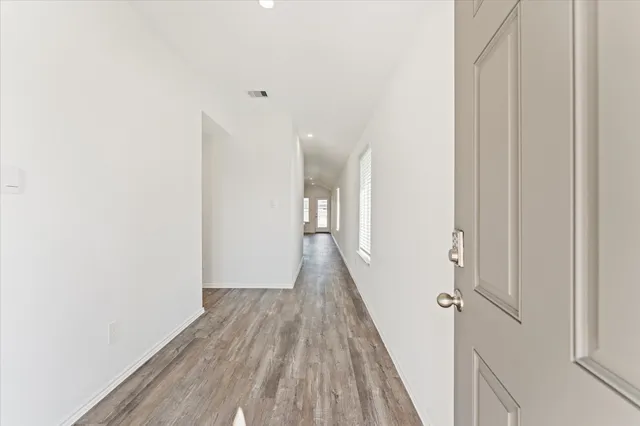a view of a hallway with wooden floor