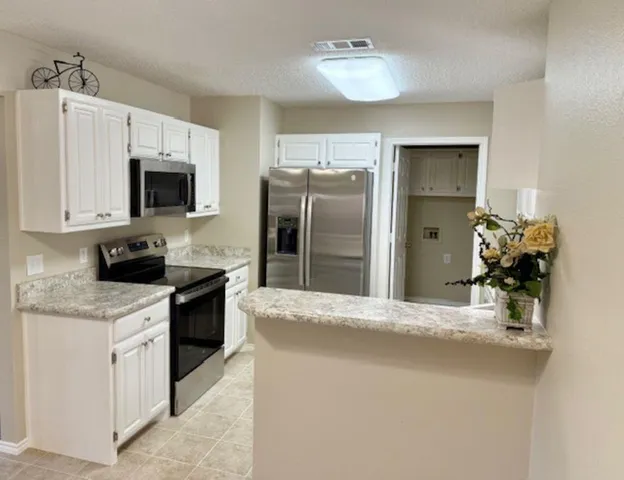 a kitchen with granite countertop cabinets and white appliances