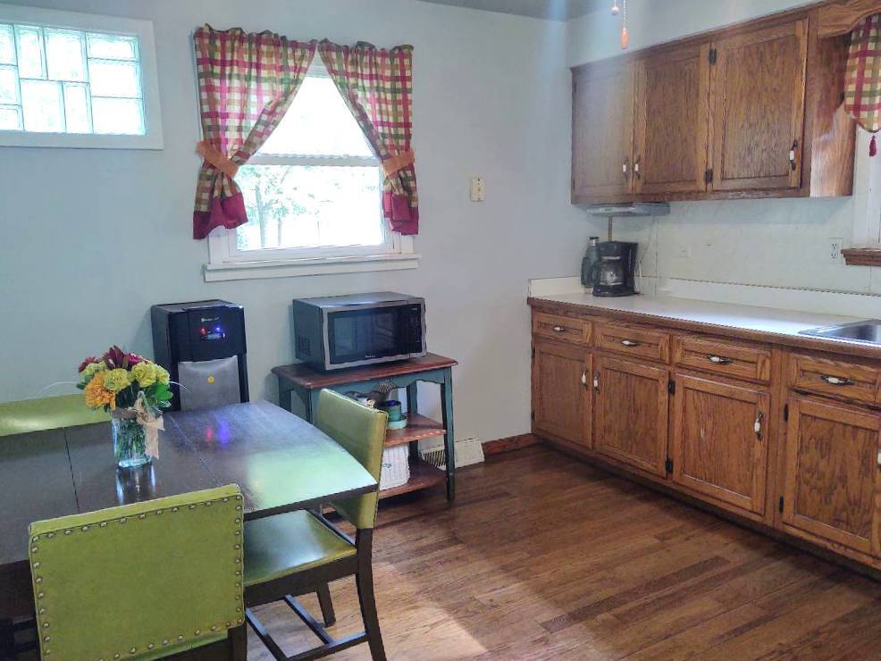 5255 Sand Ridge Road Morris, IL 60450 - Photo 6 of 20 a kitchen with stainless steel appliances granite countertop a sink dishwasher a microwave oven a dining table and chairs with wooden floor