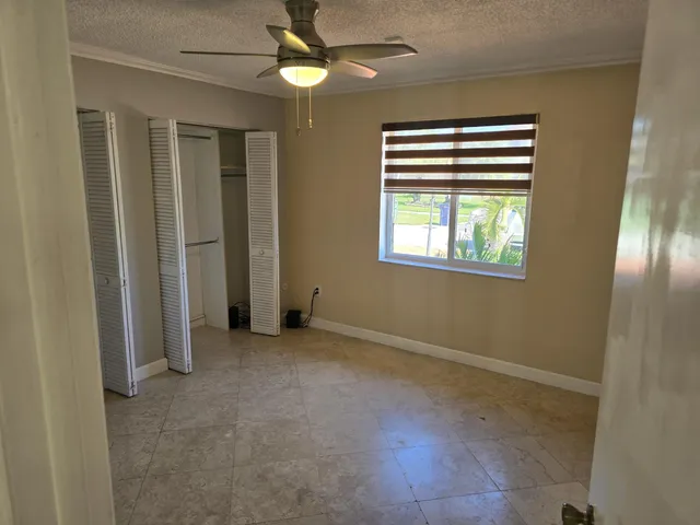 an empty room with windows and fan