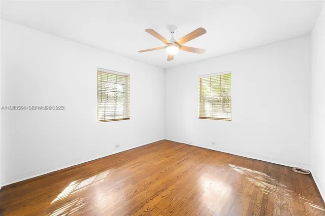 a view of a big room with wooden floor and windows