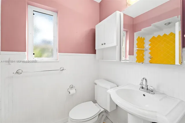 a bathroom with a toilet sink and mirror