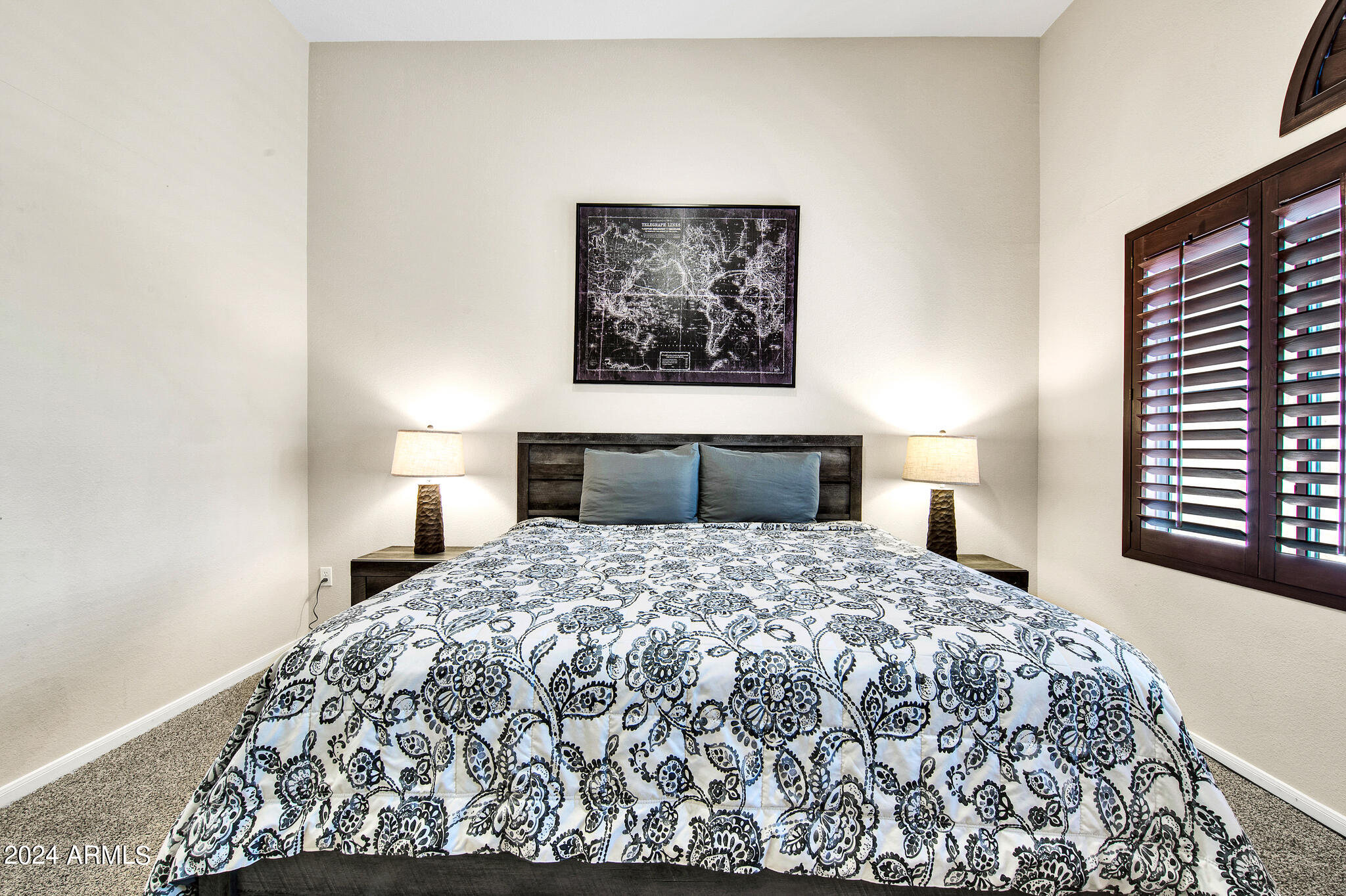 8245 East Bell Road, Unit 209 Scottsdale, AZ 85260 - Photo 23 of 49 a bedroom with a bed and a lamp on dresser