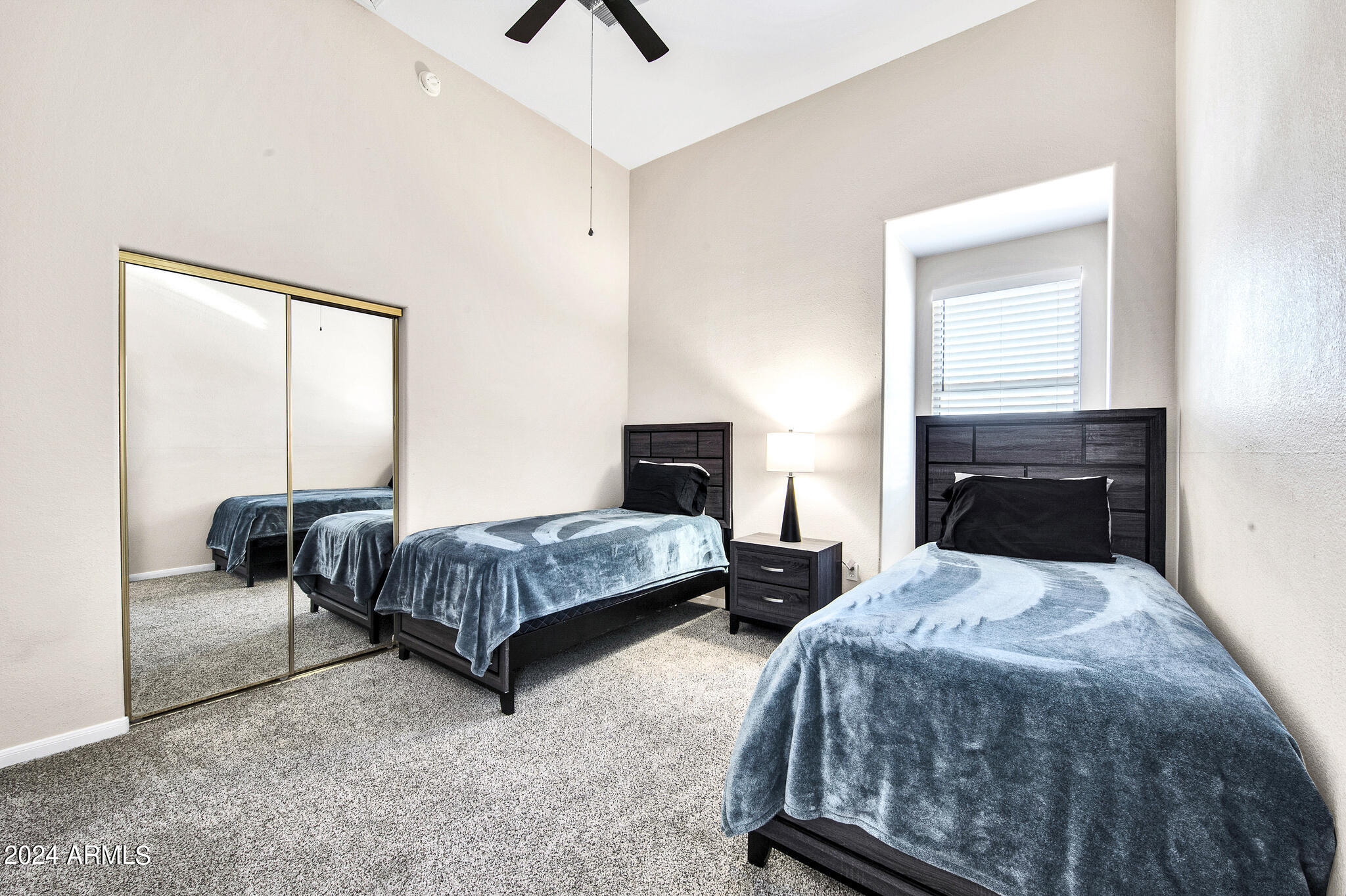 8245 East Bell Road, Unit 209 Scottsdale, AZ 85260 - Photo 32 of 49 a bedroom with two beds and a window
