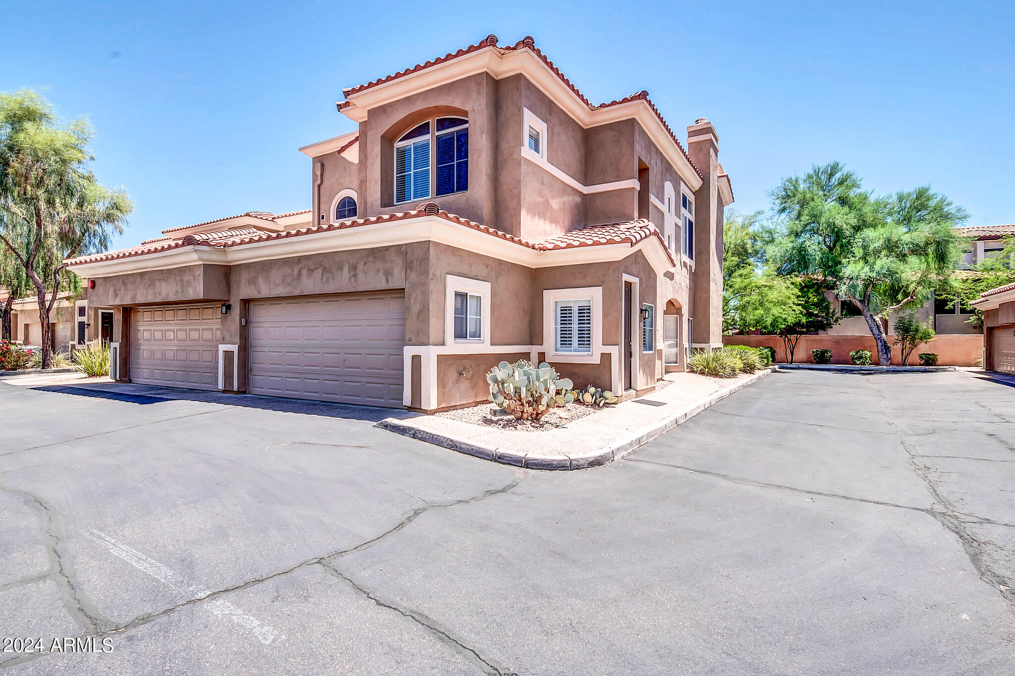 8245 East Bell Road, Unit 209 Scottsdale, AZ 85260 - Photo 5 of 49 a view of a white house with large windows next to a road