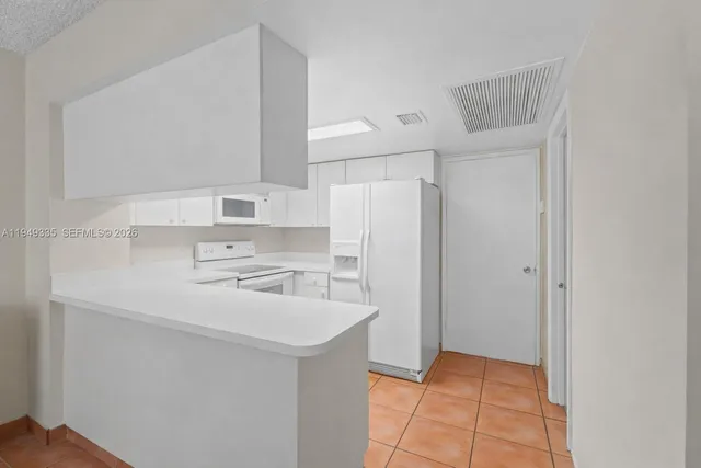 a kitchen with a sink a refrigerator and cabinets