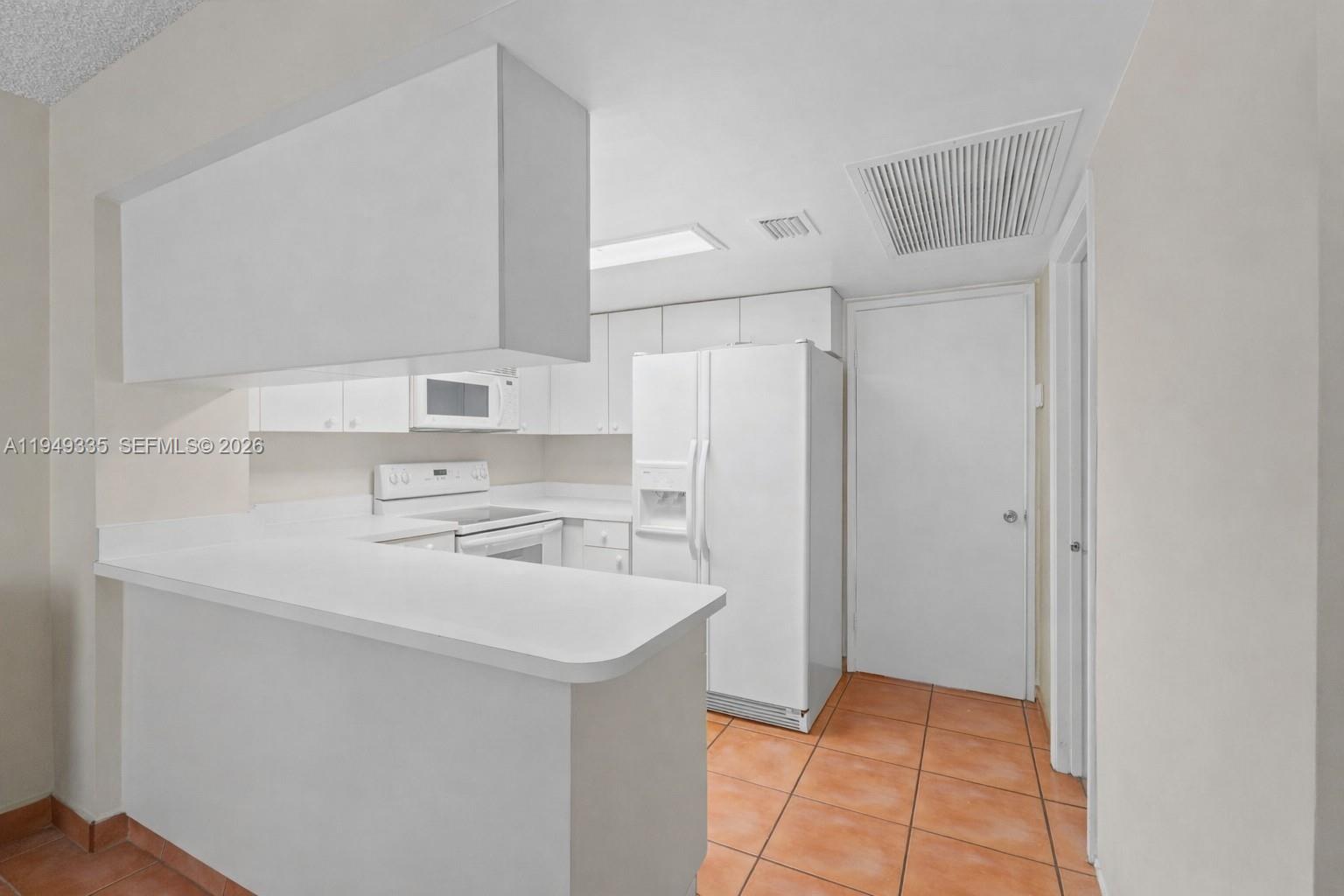 2178 West 60th Street, Unit 18111 Hialeah, FL 33016 - Photo 3 of 17 a kitchen with a sink a refrigerator and cabinets