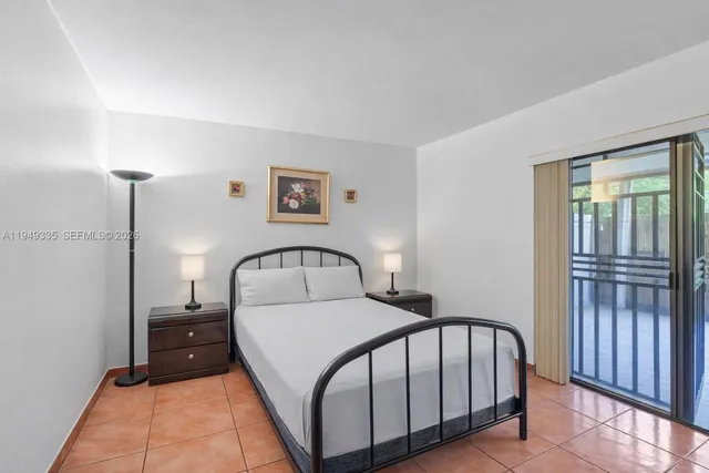 a bedroom with a bed a mirror and a window