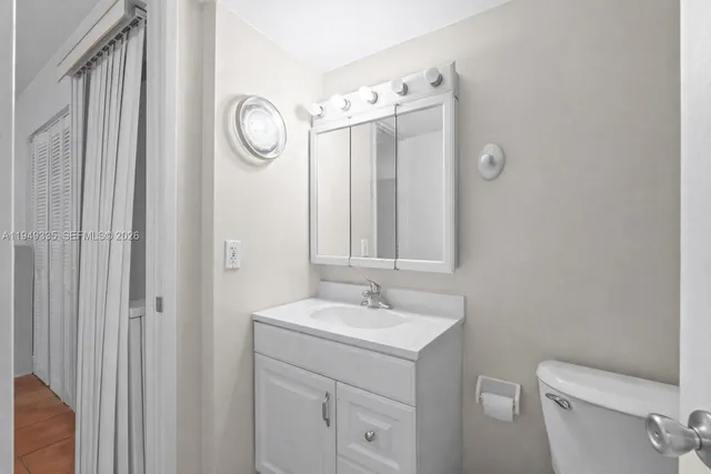 a bathroom with a toilet a sink and mirror