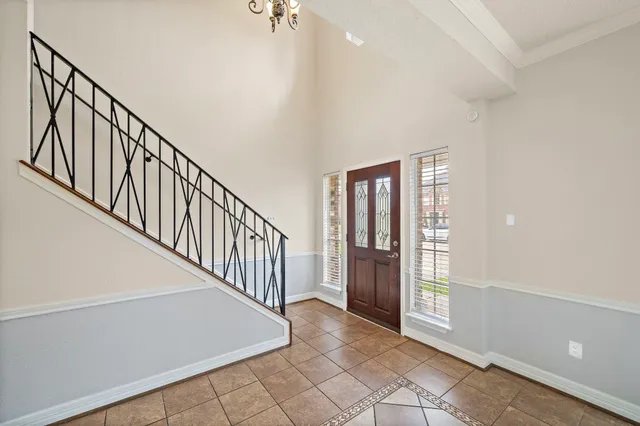 a view of a livingroom with a fireplace a ceiling fan and windows