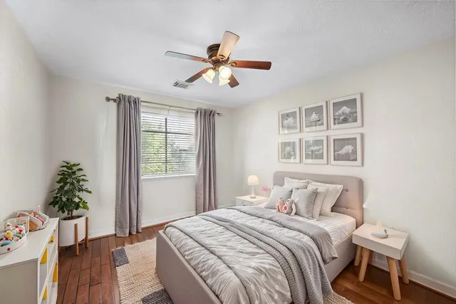 a view of a room with wooden floor and a ceiling fan