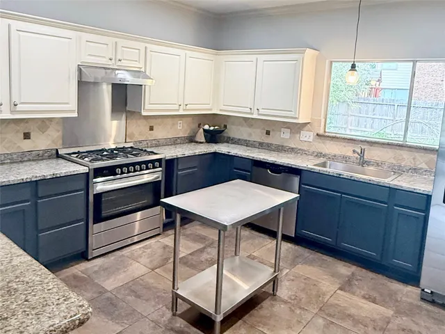a kitchen with stainless steel appliances granite countertop a stove a sink and a microwave