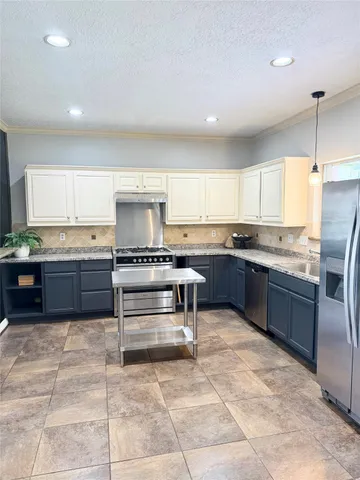 a kitchen with stainless steel appliances granite countertop a stove a sink and a refrigerator