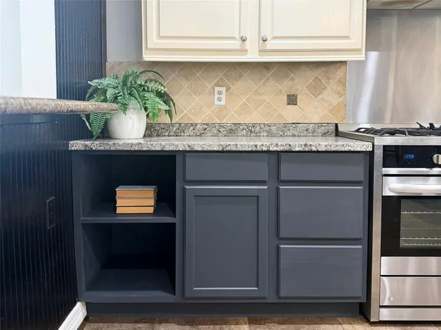 a kitchen with stainless steel appliances granite countertop a refrigerator a stove a sink dishwasher a dining table and chairs with wooden floor