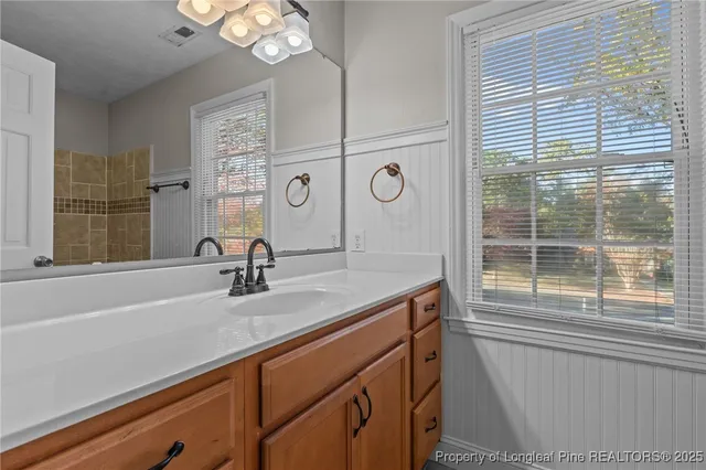 a bathroom with a sink a large mirror and a window