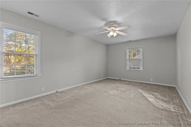 a view of an empty room with a ceiling fan
