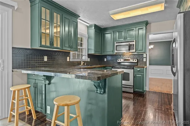 a kitchen with stainless steel appliances granite countertop a stove a sink and a microwave