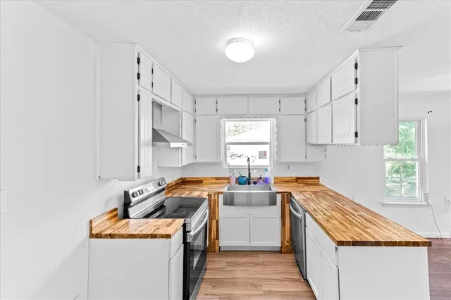 a kitchen with stainless steel appliances granite countertop a sink stove and cabinets