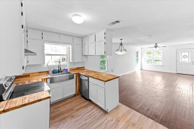 a kitchen with wooden floors and white walls