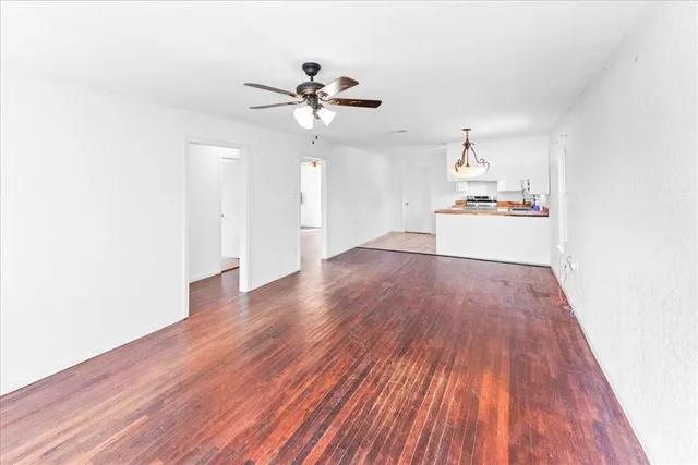 a view of empty room with wooden floor