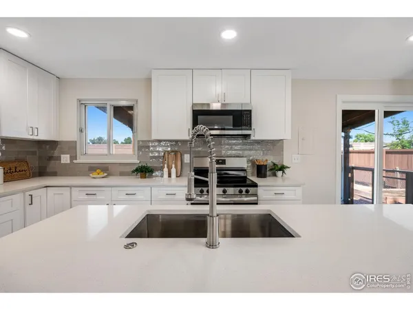 a kitchen with stainless steel appliances a stove sink microwave and cabinets