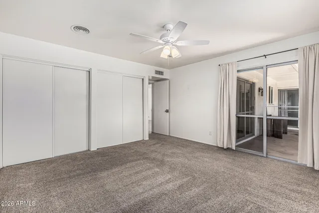 a view of a livingroom with a ceiling fan and window