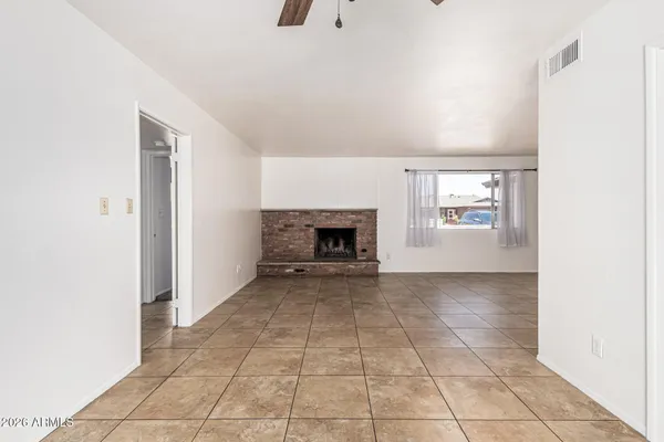 an empty room with windows and fireplace